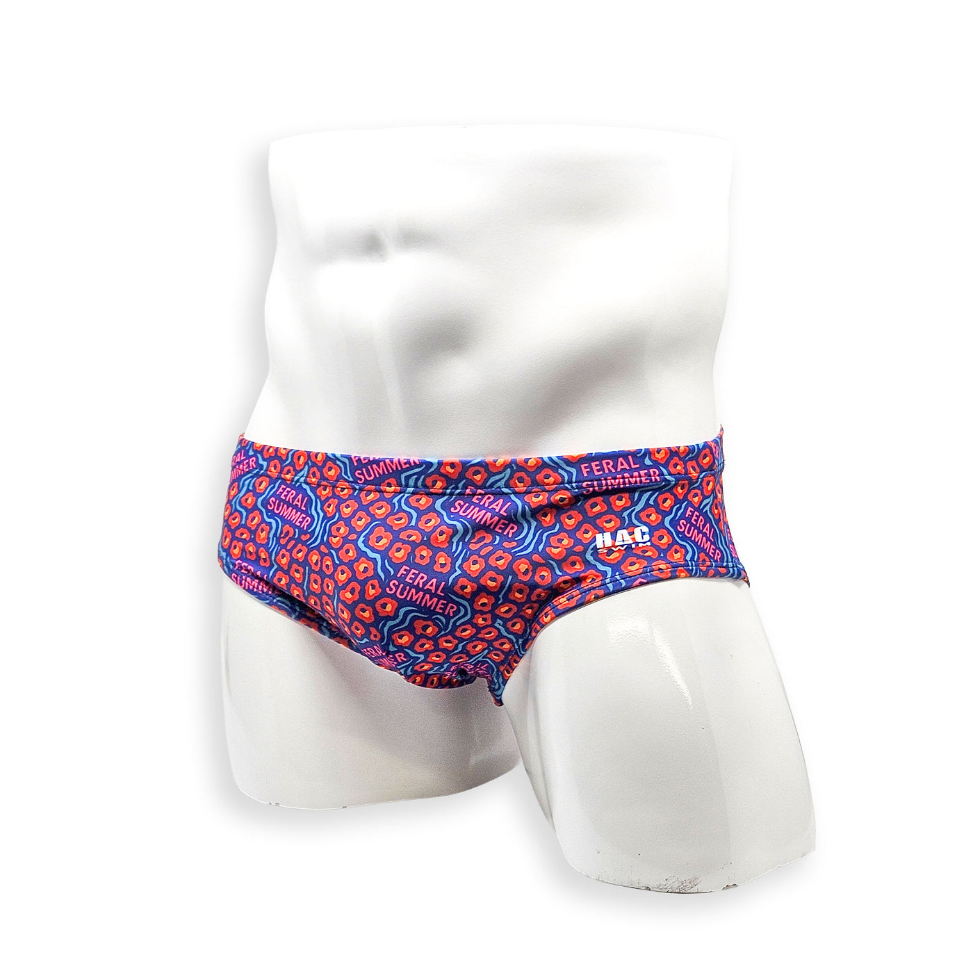 Hero view of HAC Swim Basic Swim Brief in the Feral Summer print featuring electric blue, hot pink lettering and orange abstract pattern.