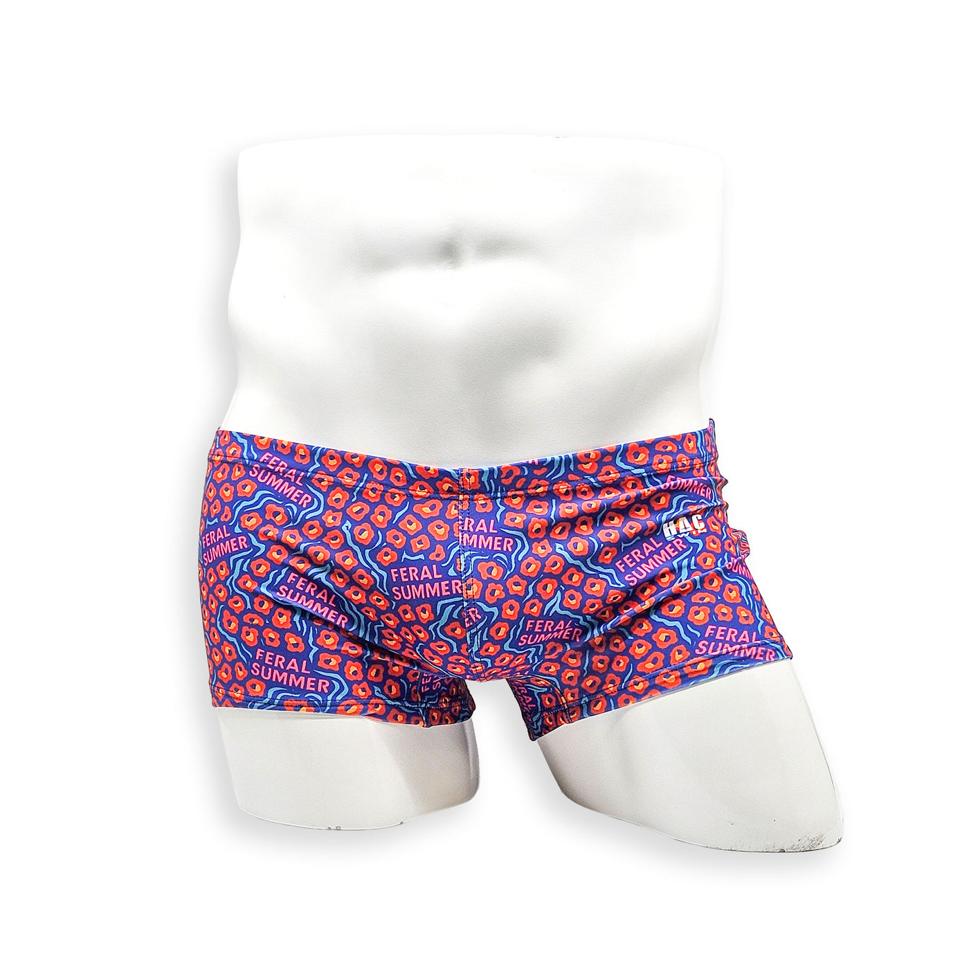 Front view of HAC Swim Box Cut swim trunk in the Feral Summer print featuring electric blue, hot pink lettering and orange abstract pattern.