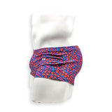 Side view of male model wearing HAC Swim Feral Summer Box Cut swim trunk with low-rise fit and bold blue, pink and orange graphic print.