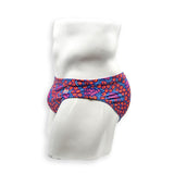 Side view of male model wearing HAC Swim Feral Summer Flat Front swim brief with low rise fit and bold blue, pink and orange graphic print.