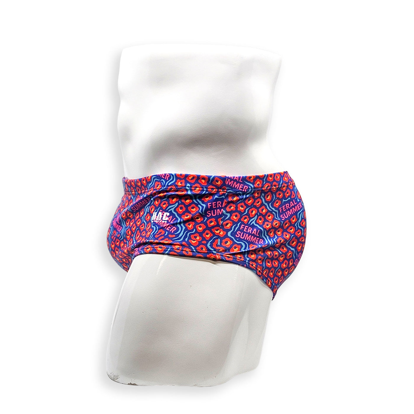 Side view of male model wearing HAC Swim Feral Summer Vintage Swim Brief with classic fit and bold blue, pink and orange graphic print.